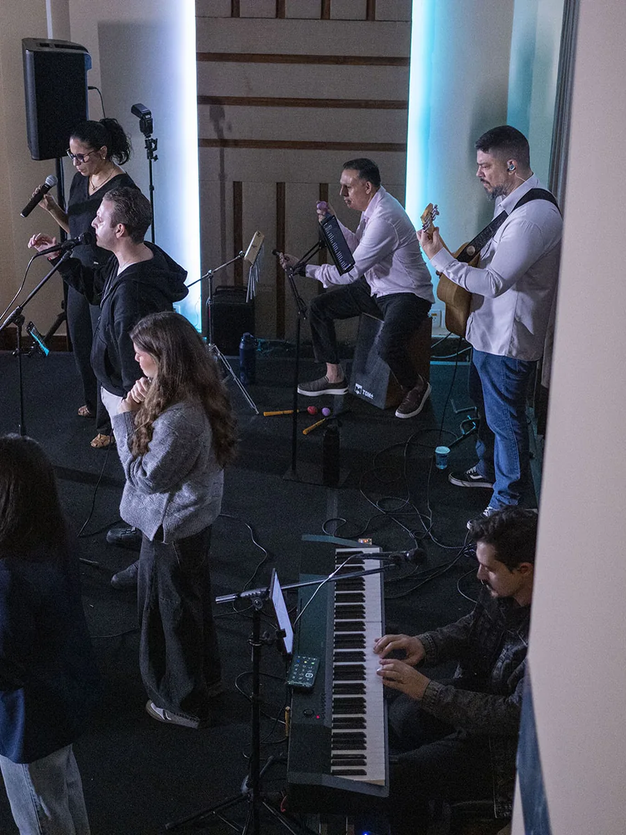 Músicos e cantores se apresentando com microfones, violão e teclado na Marvelous Casa